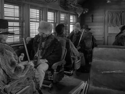 Uomini che aspettano su un mezzo di trasporto muniti di armi in una scena di Dead Man (1995)