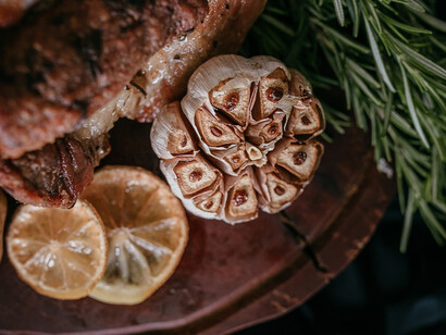 Nestled gracefully on a wooden board, a masterpiece unfolds - cooked meat, accompanied by tender potatoes and a hint of zesty lemon, forming an exquisite culinary presentation