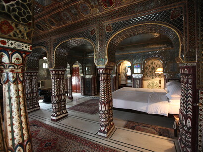 Located in the heart of Jaipur, the Sheesh Mahal Suite at Samode Haveli reflects the opulence of Rajasthani heritage with its exquisite mirror detailing and elegant interiors, India