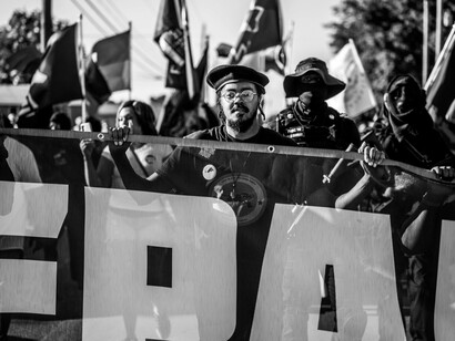 Protesters marching together with a banner held high, illustrating the collective demand for better governance and national progress