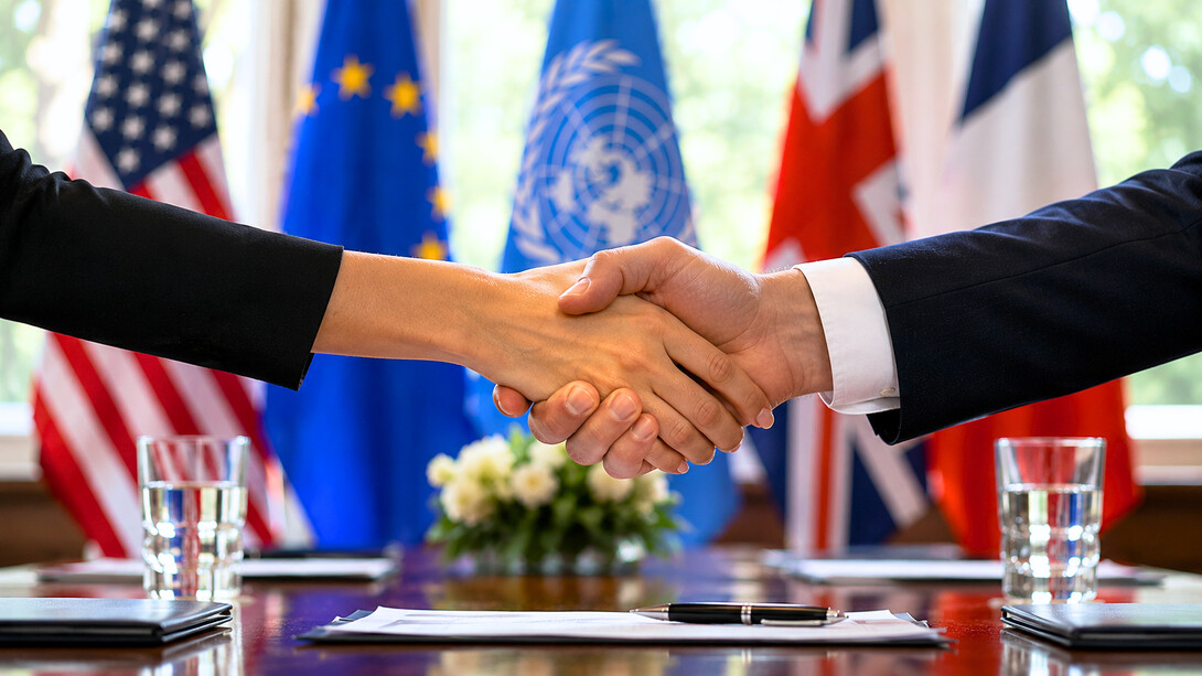 Hands meeting before international flags, reflecting the urgent need for cooperation among rival powers