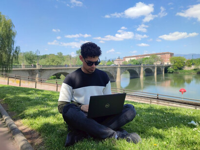 A remote-working expat man, seated with his laptop, embracing life and work abroad