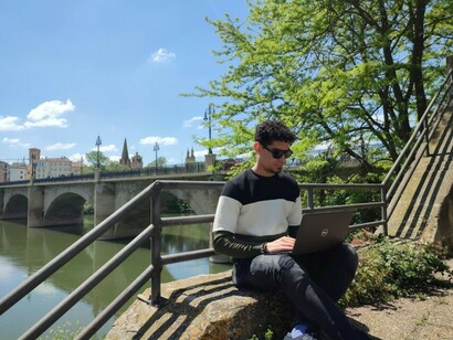 A man sits with his laptop, living the expat life and working remotely abroad