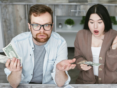 A man and woman reviewing their household budget, capturing the emotional strain of financial anxiety and economic stress