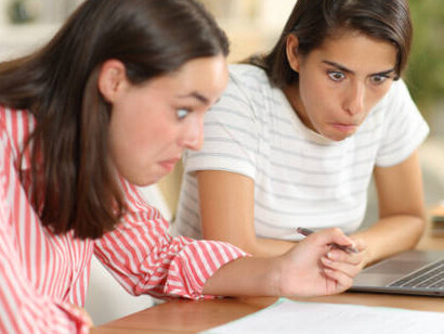 Two girls are staring at the internet, shocked by the memes they just discovered