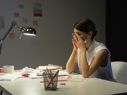 Stressed professional woman working late in an empty office