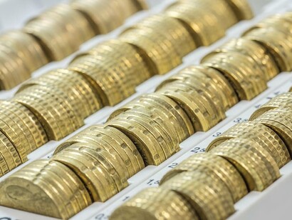 Vista ravvicinata di diverse file di monete in euro impilate ordinatamente in un sistema di conteggio manuale