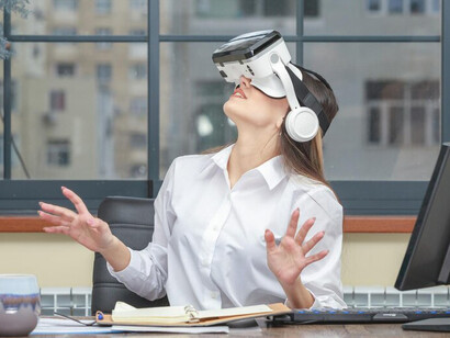 A young woman wearing a VR headset and looking up in the office