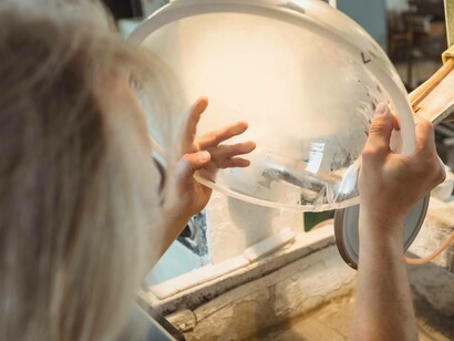 Soffiatore che lucida e mola un oggetto di vetro