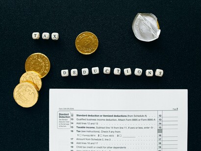 Tax documents paired with scattered coins, reflecting the personal impact of broader economic strategies