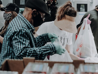 A dedicated woman volunteer sorting food into shopping bags for those in need