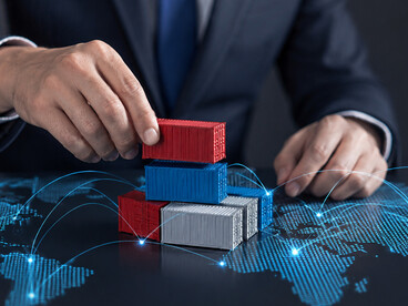 A businessman holding shipping containers before a global trade map, representing international logistics, exports, imports, and economic integration