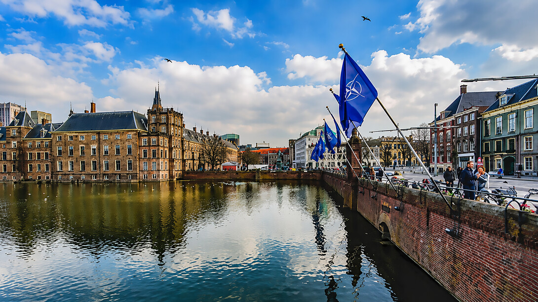 NATO flags lining a canal embankment in the heart of The Hague, Netherlands