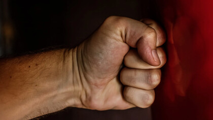Mano che batte contro una superficie liscia rossa per rabbia