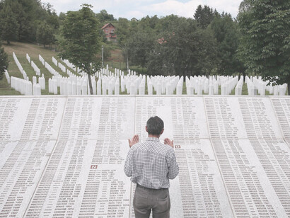 Hombre reza frente a los nombres de las víctimas en el Monumento del Genocidio de Srebrenica