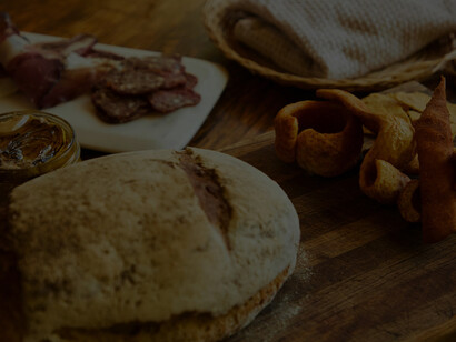 Arranged with precision, a tempting selection of cured meats steals the spotlight, accompanied by the elegance of a meticulously presented glass of wine