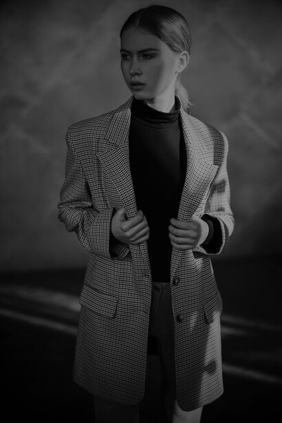 Modelo veste um blazer quadriculado com camiseta gola chacharrel