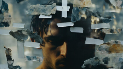 A man symbolizing the weight of humanity’s unhealed wounds and the repetition of past atrocities 