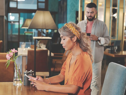 Embarking on their first date, a man and woman rendezvous at a delightful venue, clinking glasses of wine, their conversation blending with the subtle excitement of newfound connection