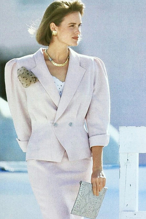 A woman wearing a white power suit with a skirt for a professional and stylish look