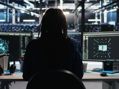 A data center engineer analyzes AI network visualizations using node-based software, mapping complex data flows