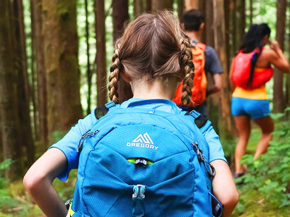A young girl confidently wearing her blue backpack, a symbol of her growing self-identity and adventurous spirit