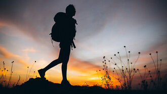 A woman rucking on the mountain during sunset