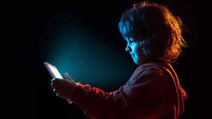 A boy appears frustrated while vlogging with a tablet, capturing the emotional impact of technology on children and the challenges posed by digital distractions