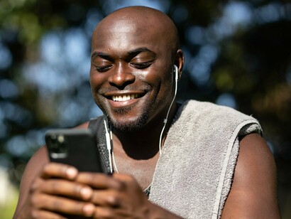 A man checking his phone while outside, symbolising the convenience of managing money digitally