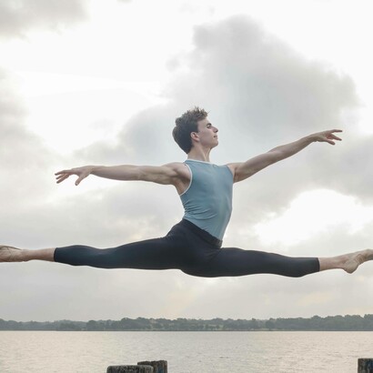Ballerino che esegue una spettacolare spaccata a mezz'aria in una posa di danza classica