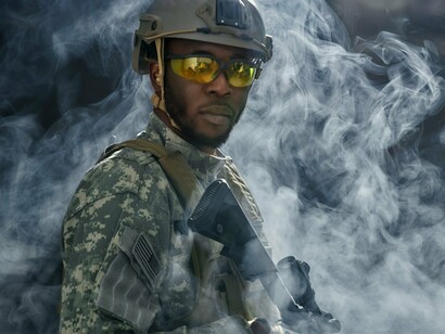 A soldier surrounded by smoke, symbolizing the looming presence of war over resource-rich regions