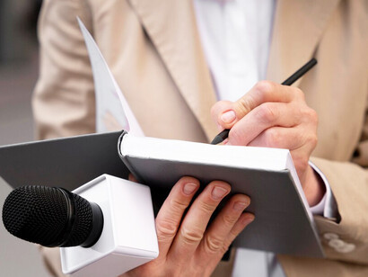 A focused shot of a journalist preparing for an interview, symbolizing the tension between media censorship and the pursuit of press freedom