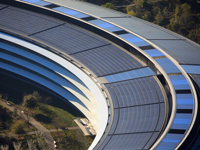 A sede da Apple tem o formato de disco em que o centro e as extremidas são encobertas por árvores e paisagem verde na cidade de Cupertino, Califórnia nos Estados Unidos