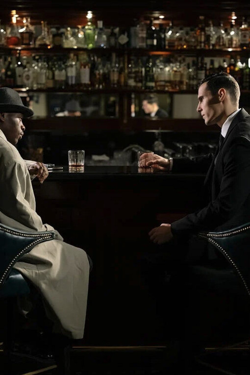 Dos hombres bebiendo y poniéndose de acuerdo en la barra del bar
