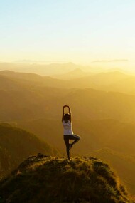 A meditation enthusiast doing yoga on a cliff and enjoying the spiritual freedom and physical strength it brings