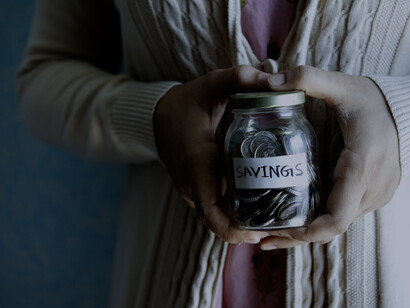 A woman holds her savings in a jar