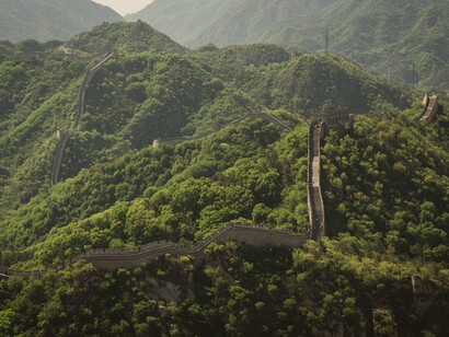 Torres e muralhas se estendem pelo relevo montanhoso, revelando a grandiosidade da engenharia chinesa. O patrimônio histórico ajuda a compreender as raízes de uma civilização que volta a ocupar espaço central no cenário global