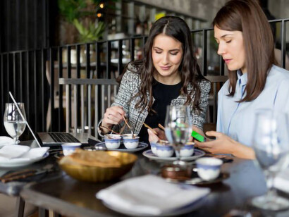 Enjoying a hearty lentil soup, two young ladies share a lunchtime moment
