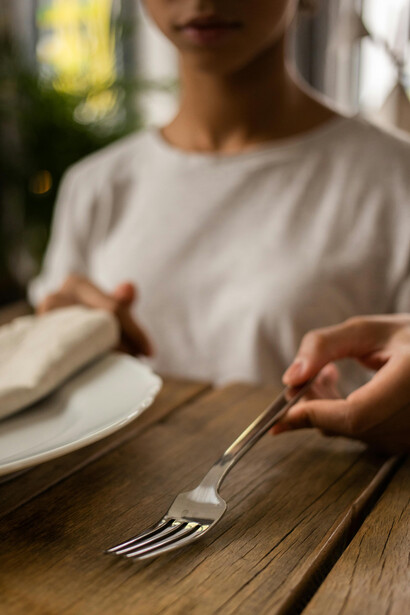 Criança estuda sobre as funções dos talheres em aula de etiqueta na sua casa