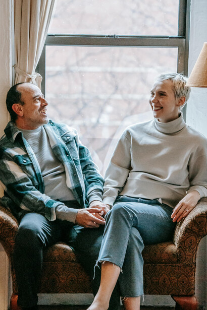 A happy couple sitting on a couch and talking together