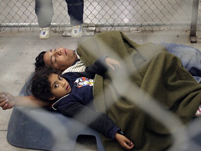 Maer Torrescano, 6, rests with his father Havacuc, 24, from the state of Morelos, Mexico, at the U.S. Border Patrol detention center in Nogales, Arizona, May 31, 2006. REUTERS/Jeff Topping