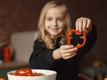 A girl cooking a nutritious vegetable curry in the kitchen, featuring broccoli, to support the Zero Hunger Initiative