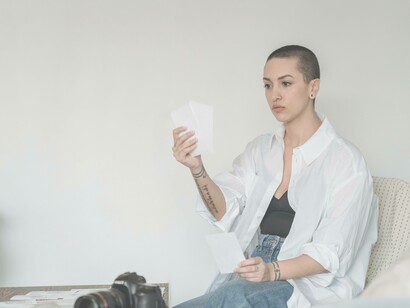 A woman looking deeply into the photographs in her hands while she's contrasting and making comparisons