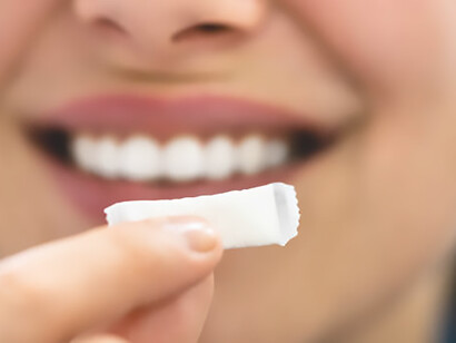 The act of a woman chewing wet, moist nicotine tobacco snus, depicting the tactile sensation and nuanced nature of this form of tobacco consumption