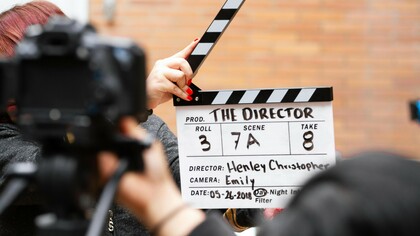 A man holding a clapperboard, symbolizing Russian cinema's growing presence in Hollywood