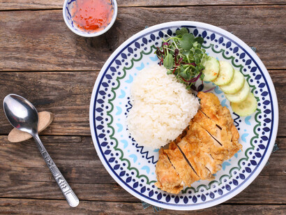 A delicious serving of crispy chicken katsu is paired with rice and fresh salad