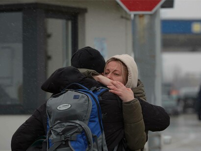 A woman is seen hugging someone goodbye; A scene from the Palanca-Maiaki-Udobnoe border crossing point, between the Republic of Moldova and Ukraine on 4 March 2022.  Photos from the UN Women