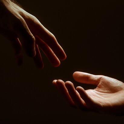 Acercamiento a un par de manos a punto de tocarse