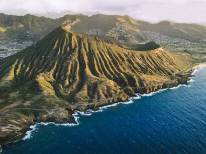 The stunning vistas of Oahu, Hawaii, from above, as the aerial view captures the picturesque mountains and tranquil ocean, offering a glimpse of the island's captivating natural scenery