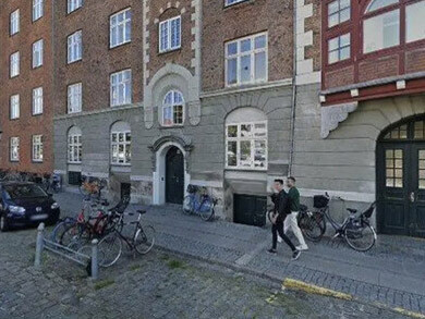 El paso de una arquitectura que se transmitía y se deformaba con el tiempo a otra que se ejecuta en un presente continuo, siempre actualizable, siempre optimizable. En una calle y vereda de piedras, 2026, Copenhague, Dinamarca